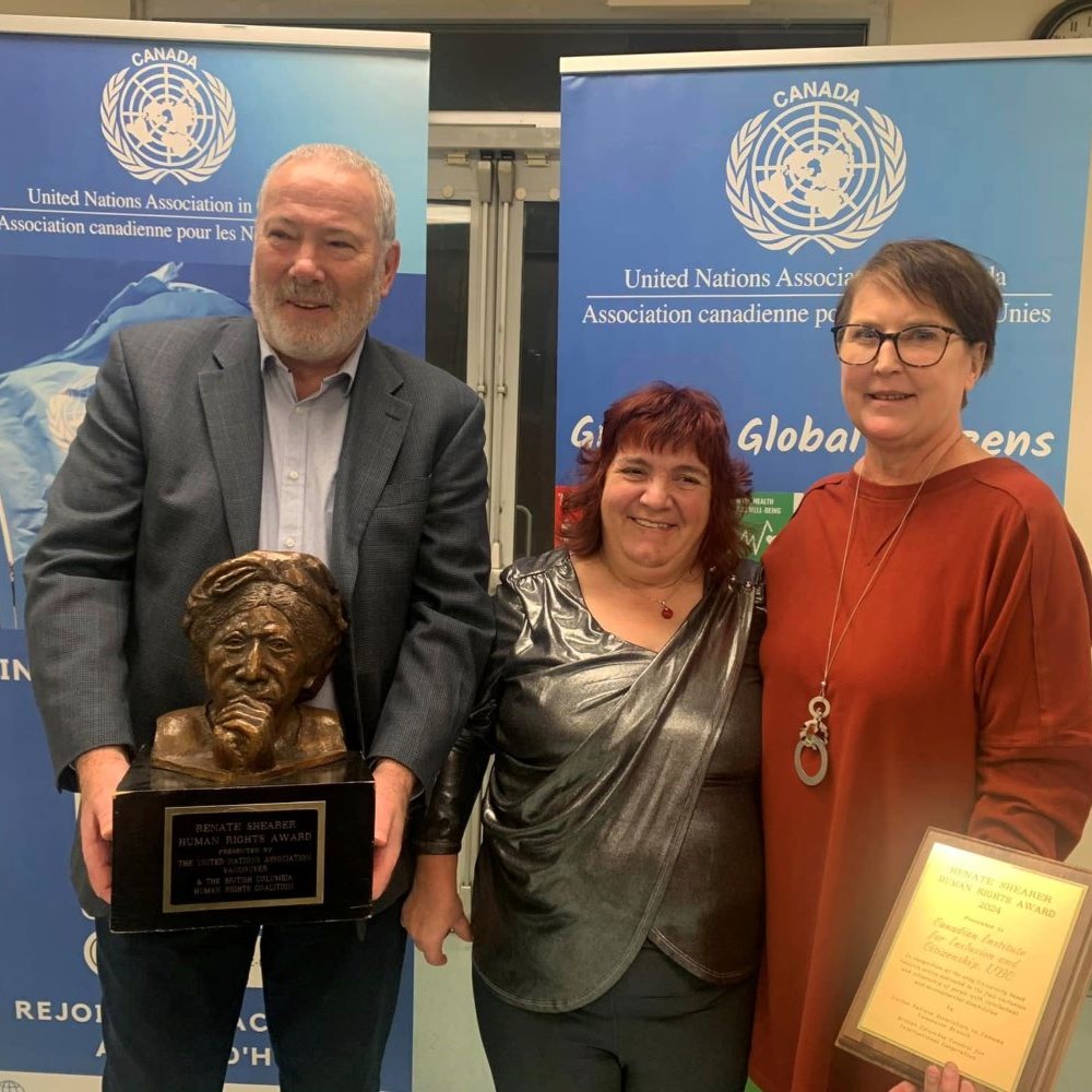 Tim Stainton, Rachelle Hole and Renata Shearer posing and holding an award